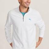 Man wearing a white quarter-zip sweatshirt with a logo on a beige background