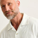 Man wearing a light-colored shirt against a plain background