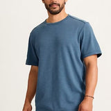 Man wearing a blue t-shirt and pink pants on a white background