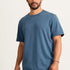 Man wearing a blue t-shirt and pink pants on a white background