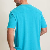 Man wearing a turquoise t-shirt against a plain background