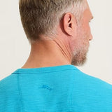 Man wearing a blue polo shirt with a small logo on a plain background