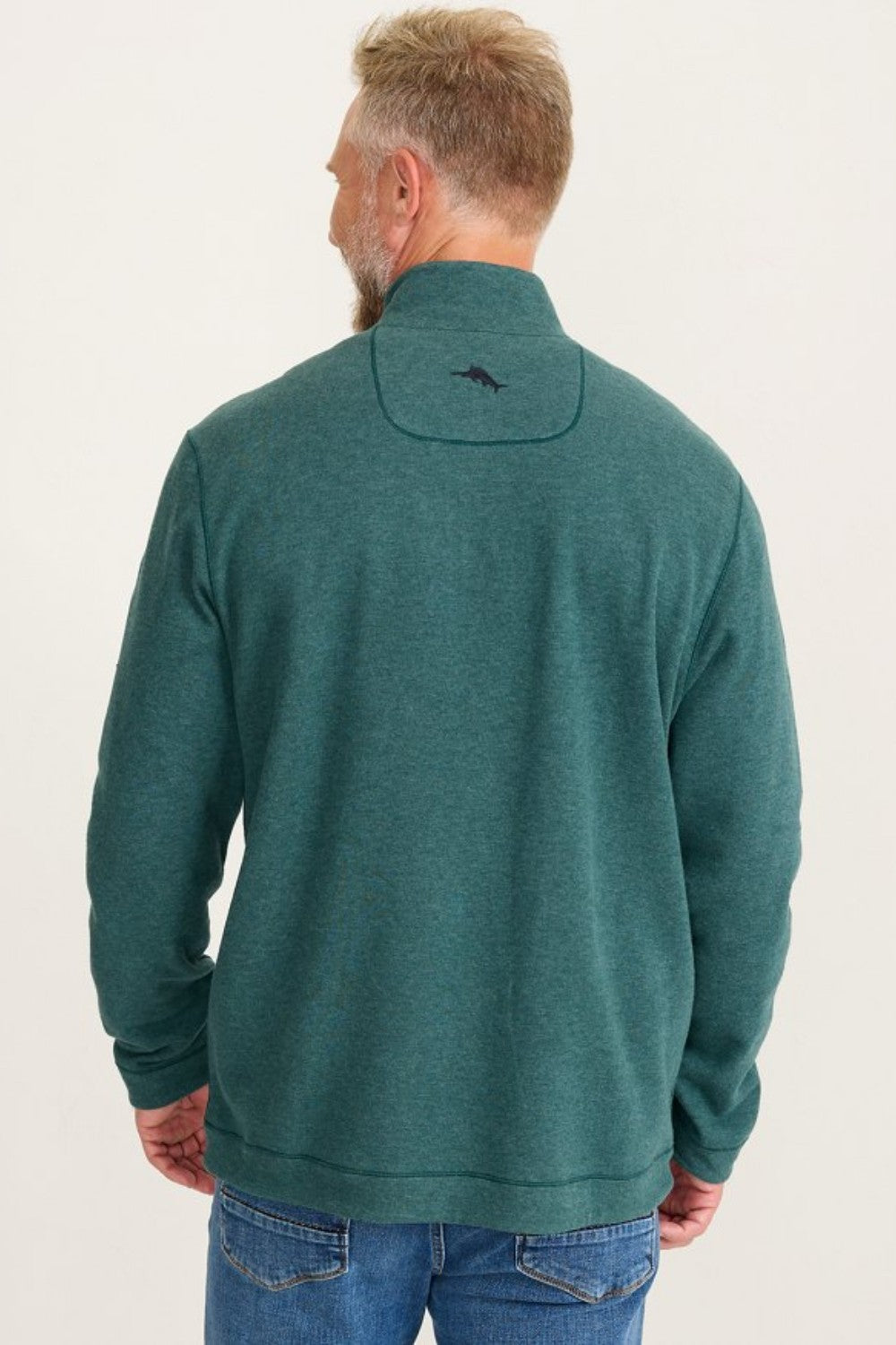 Man wearing a green fleece pullover with a logo on the back against a white background