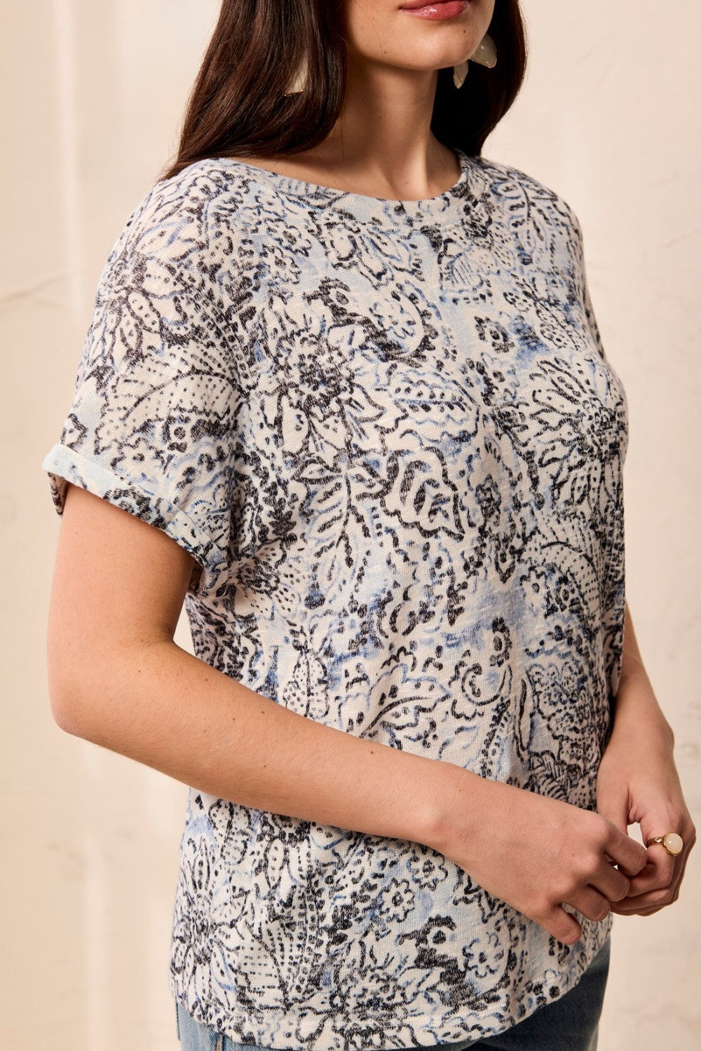 Woman wearing a patterned top against a beige background