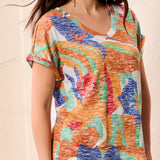 Woman wearing a colorful patterned top with a blurred background