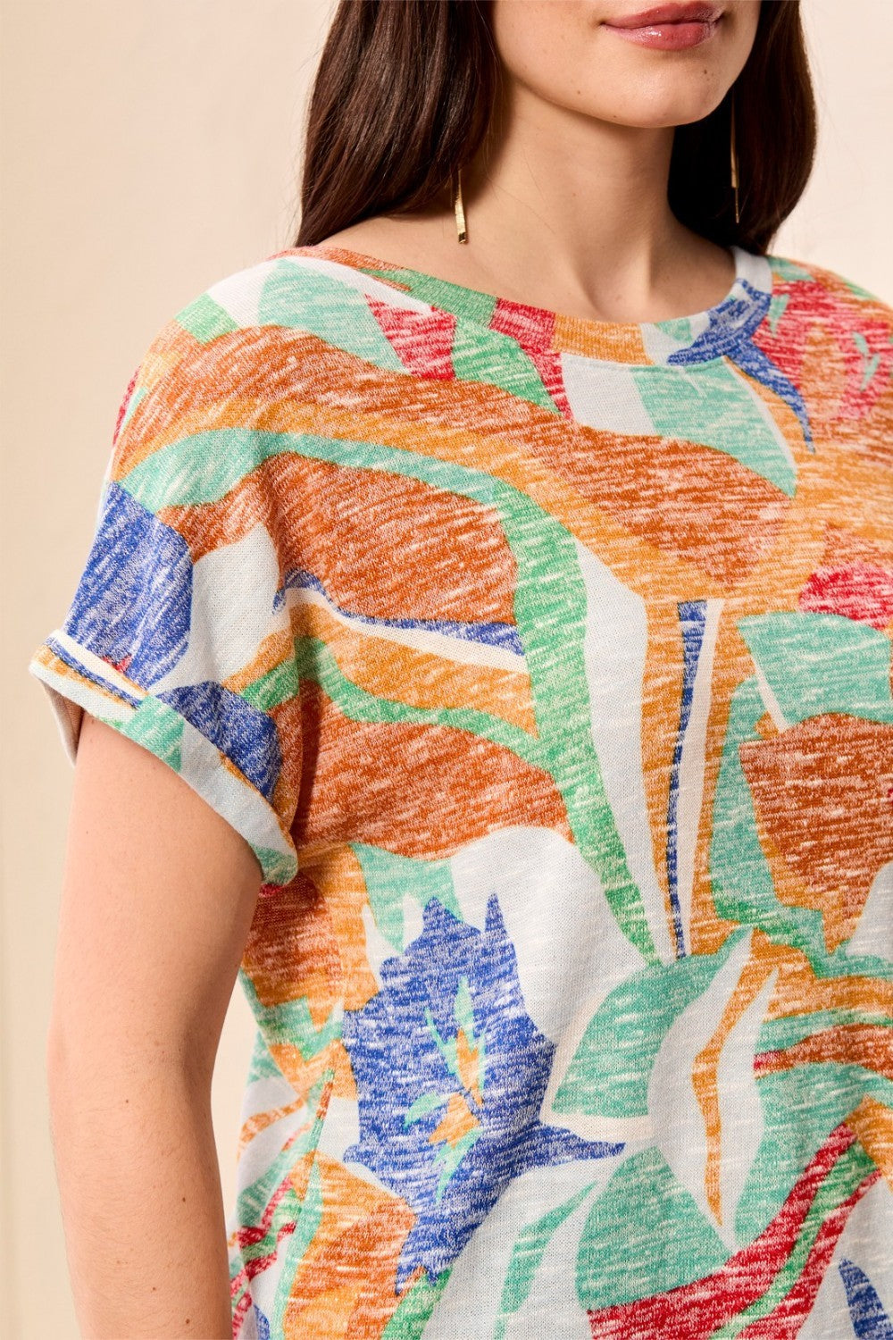 Person wearing a colorful patterned top with a neutral background