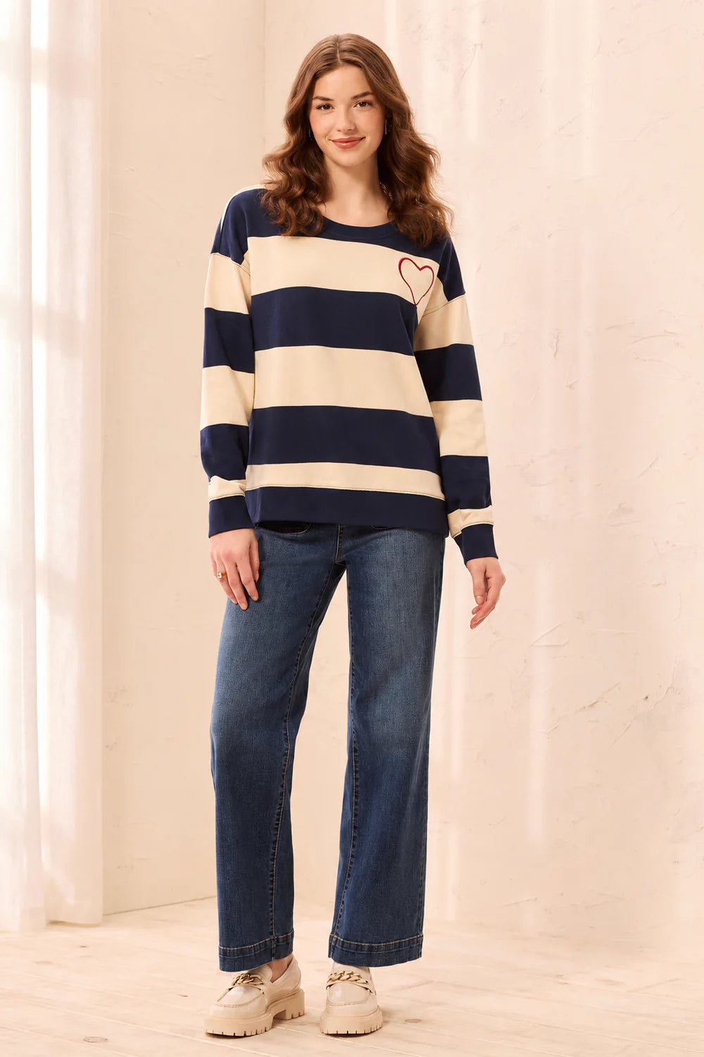 This charming long-sleeve knit pullover features a classic nautical stripe pattern accented by a vibrant embroidered red heart for a playful, romantic touch. Designed with a relaxed drop shoulder and a cozy crew neckline, it offers an effortless silhouette that perfectly balances casual comfort with elevated style.