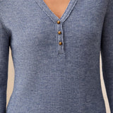 Blue textured long-sleeve shirt with button details on a neutral background