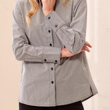 Woman wearing a black and white striped shirt against a beige background