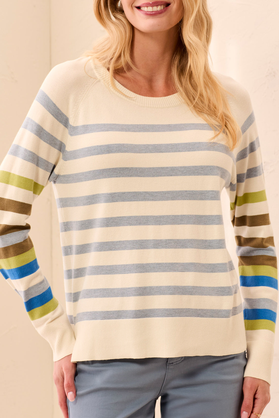 Woman wearing a striped sweater with a plain background