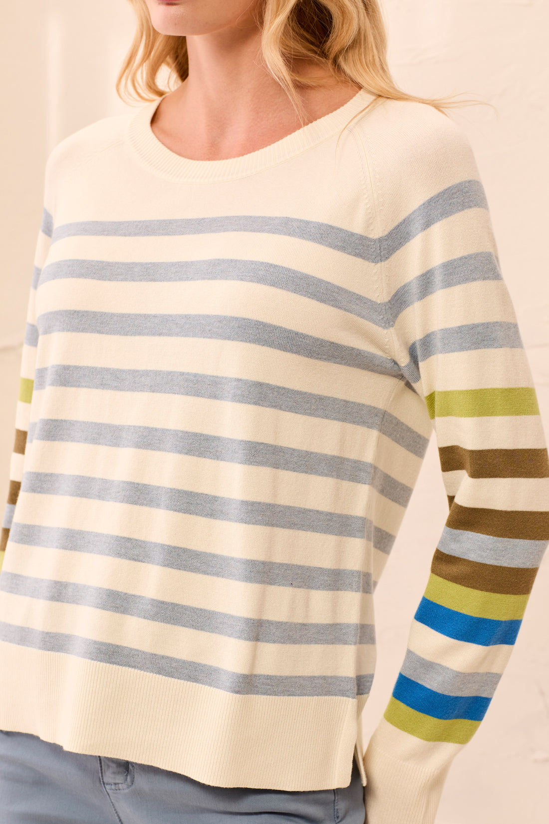 Close-up of a person wearing a striped sweater with a neutral background