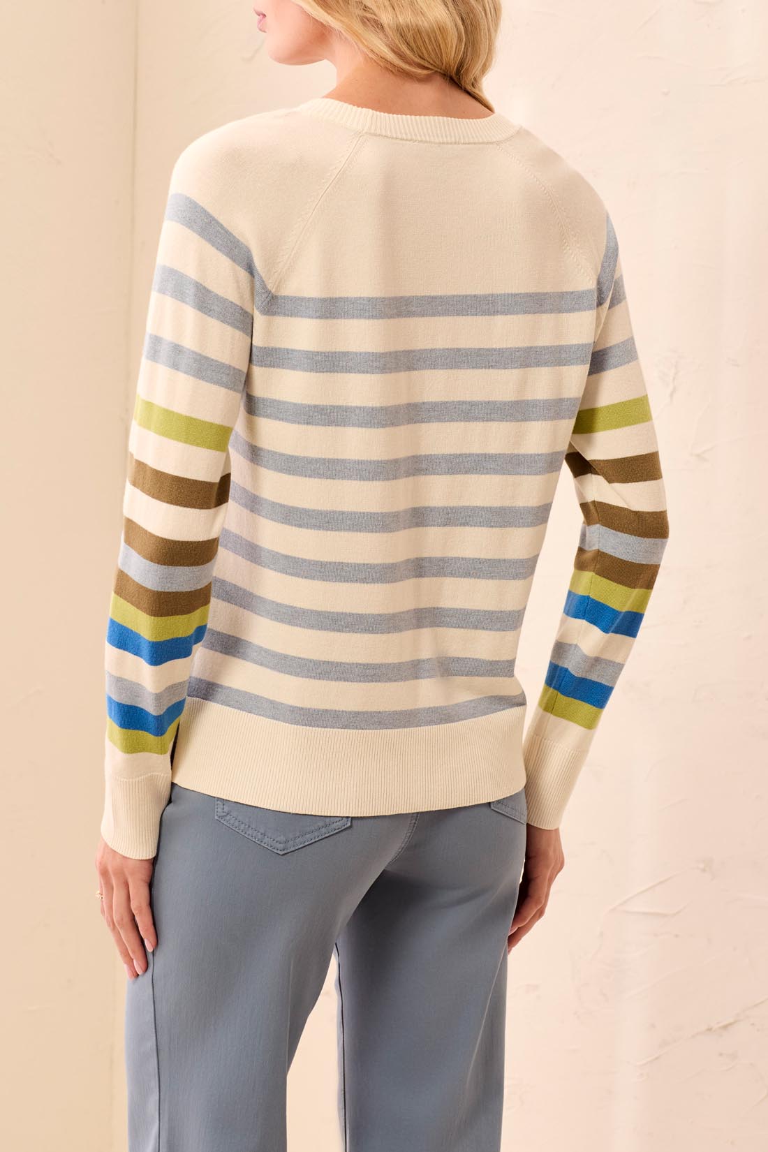 Person wearing a striped sweater with a neutral background