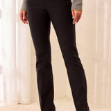 Person wearing black pants with a neutral background