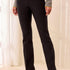 Person wearing black pants with a neutral background
