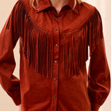 Woman wearing an orange fringed shirt with a blurred background