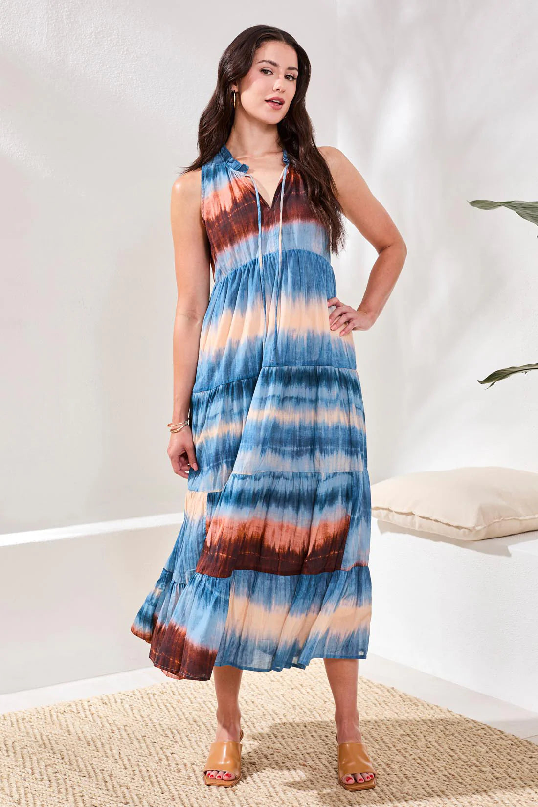 Woman wearing a tie-dye dress in a minimal indoor setting