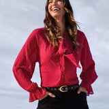 Woman wearing a pink blouse with a blurred background