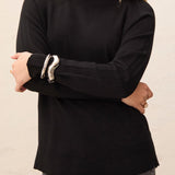 Person wearing a black turtleneck sweater against a neutral background
