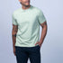 Man wearing a light green t-shirt and navy shorts on a light gray background