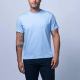 Man wearing a light blue t-shirt and dark shorts against a plain background