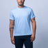 Man wearing a light blue t-shirt and dark shorts against a plain background