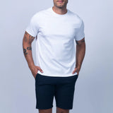 Man wearing a white t-shirt and navy shorts on a light gray background