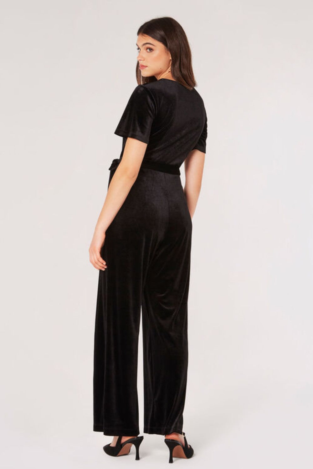 Carve an elegant silhouette in this sleek velvet jumpsuit, designed for party season. Framed by a V-neckline and angel sleeves, it boasts a flattering wrap bodice, a wide-leg cut, and side seam pockets. It's finished with a fabric belt to create a cinched-in silhouette. Style with heels and a clutch to complete the look.