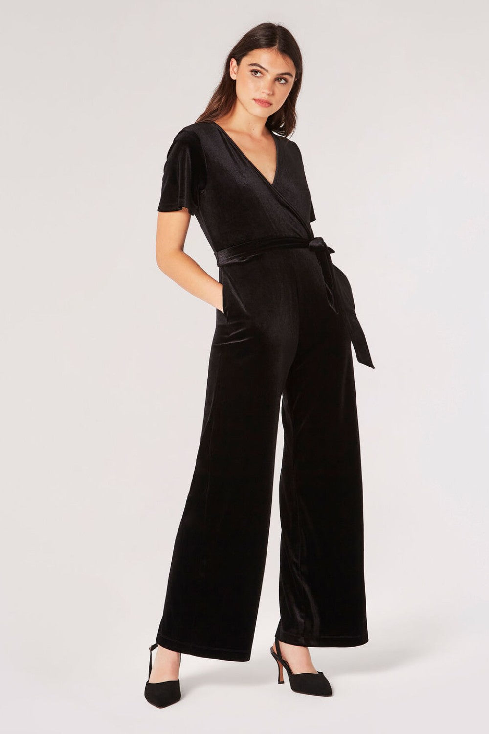 Carve an elegant silhouette in this sleek velvet jumpsuit, designed for party season. Framed by a V-neckline and angel sleeves, it boasts a flattering wrap bodice, a wide-leg cut, and side seam pockets. It's finished with a fabric belt to create a cinched-in silhouette. Style with heels and a clutch to complete the look.