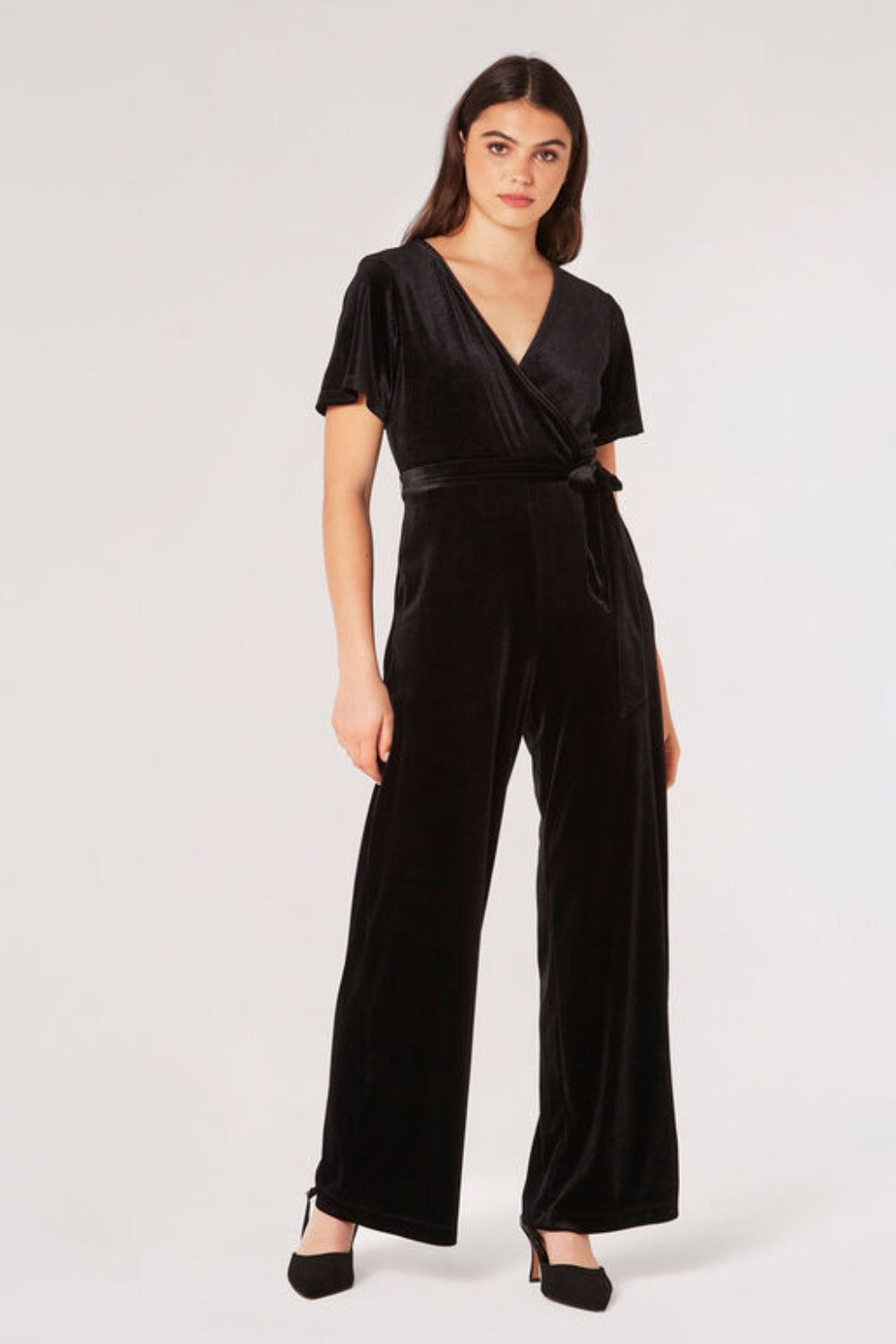 Carve an elegant silhouette in this sleek velvet jumpsuit, designed for party season. Framed by a V-neckline and angel sleeves, it boasts a flattering wrap bodice, a wide-leg cut, and side seam pockets. It's finished with a fabric belt to create a cinched-in silhouette. Style with heels and a clutch to complete the look.