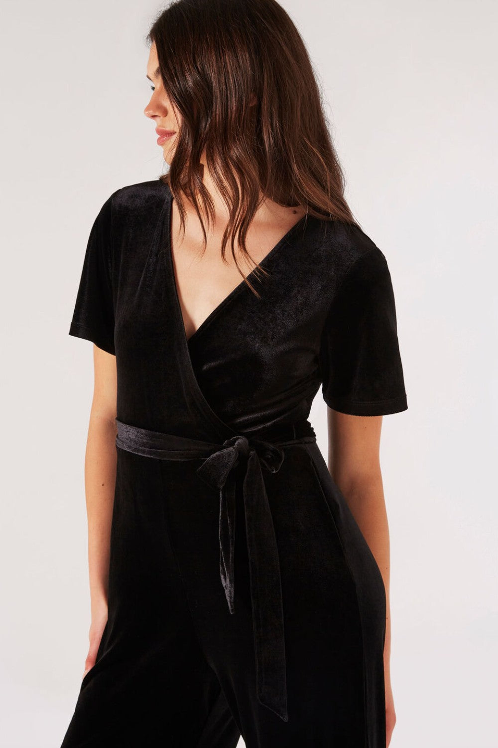 Carve an elegant silhouette in this sleek velvet jumpsuit, designed for party season. Framed by a V-neckline and angel sleeves, it boasts a flattering wrap bodice, a wide-leg cut, and side seam pockets. It's finished with a fabric belt to create a cinched-in silhouette. Style with heels and a clutch to complete the look.