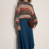 Broderick's Clothing Co. apricot mixed yarn boho jumper with open-knit stripes and mock neck worn with a blue skirt.