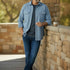 Broderick's Clothing Co. blue heathered woven shirt with button-down collar and chest pockets worn by a man outdoors.