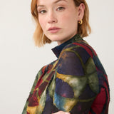 Broderick's Clothing Co. FDJ long sleeve mock neck top with a bold, multi-colored geometric print on a woman.