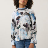 Model wearing Broderick's Clothing Co. FDJ floral print long sleeve top with a blue patterned high neck and cuffs.