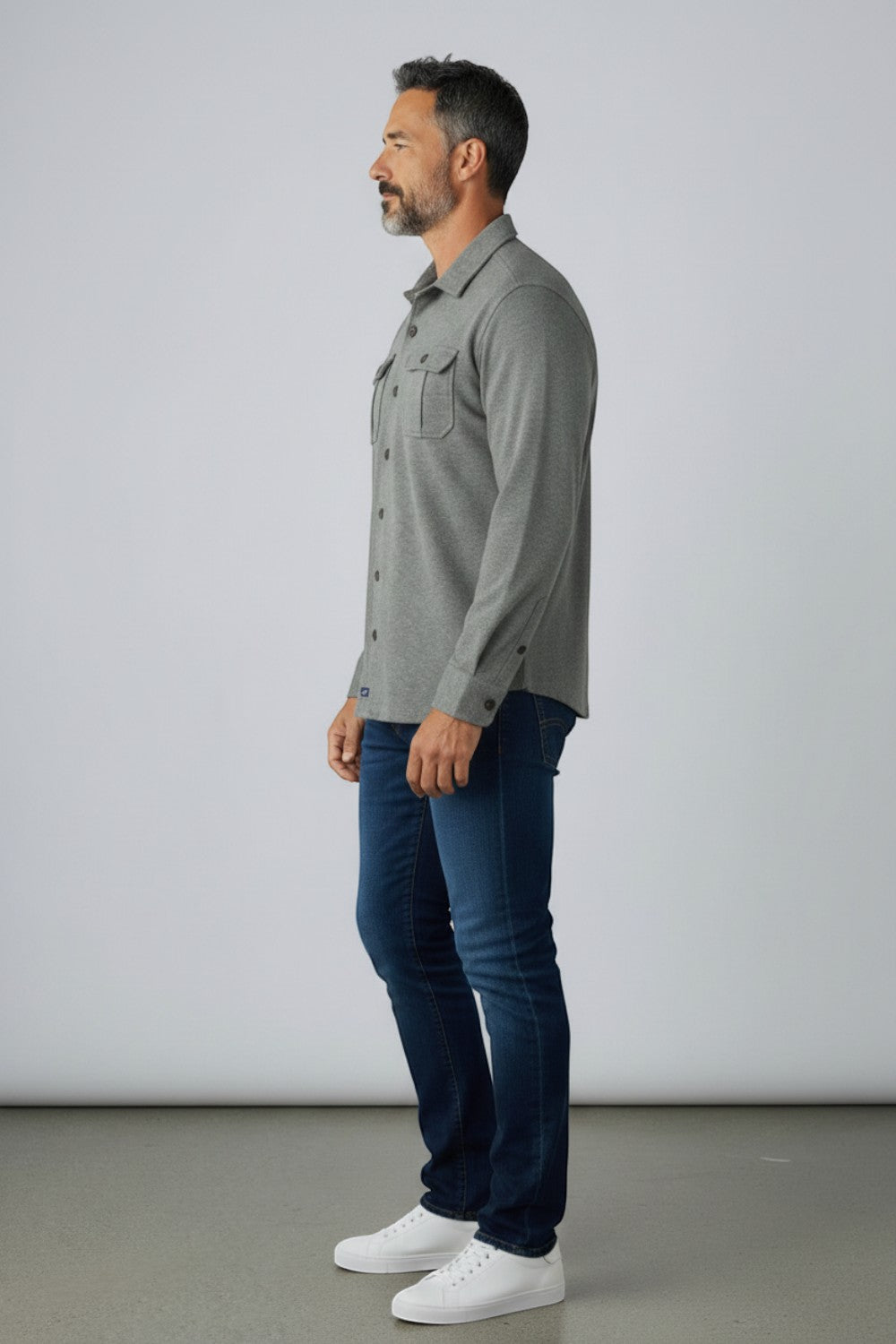 Broderick's Clothing Co. model wearing a grey Johnnie-O Sequoia twill overshirt with chest pockets and blue jeans