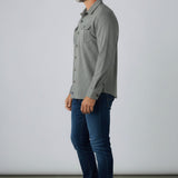 Broderick's Clothing Co. model wearing a grey Johnnie-O Sequoia twill overshirt with chest pockets and blue jeans