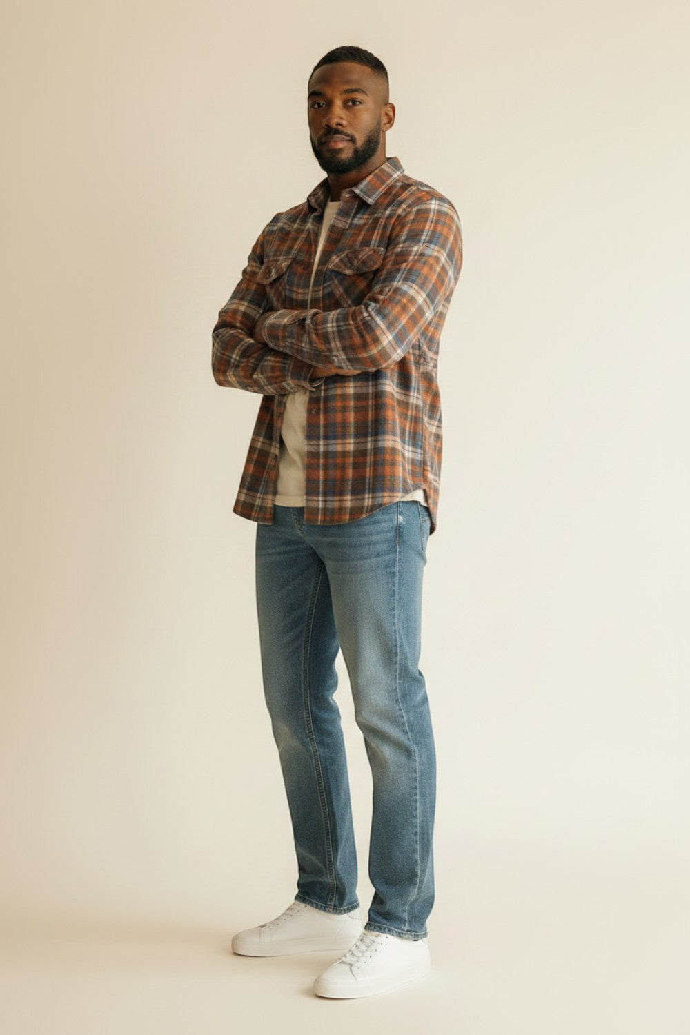 Model wearing a Broderick's Clothing Co. Johnston & Murphy heathered plaid woven shirt with jeans and white sneakers.