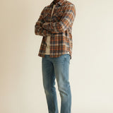 Model wearing a Broderick's Clothing Co. Johnston & Murphy heathered plaid woven shirt with jeans and white sneakers.