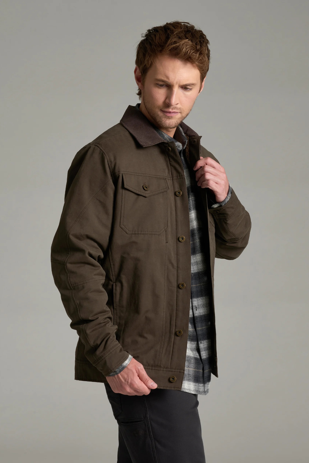 Broderick's Clothing Co. KÜHL MAVERICK brown canvas jacket with fleece lining worn by a man in a studio setting