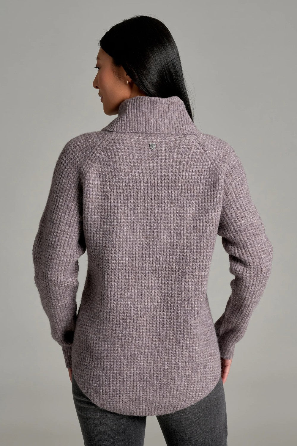 Back view of a woman wearing a Broderick's Clothing Co. KÜHL Sienna sweater in a mauve chunky knit with a cowl neck.