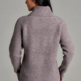Back view of a woman wearing a Broderick's Clothing Co. KÜHL Sienna sweater in a mauve chunky knit with a cowl neck.