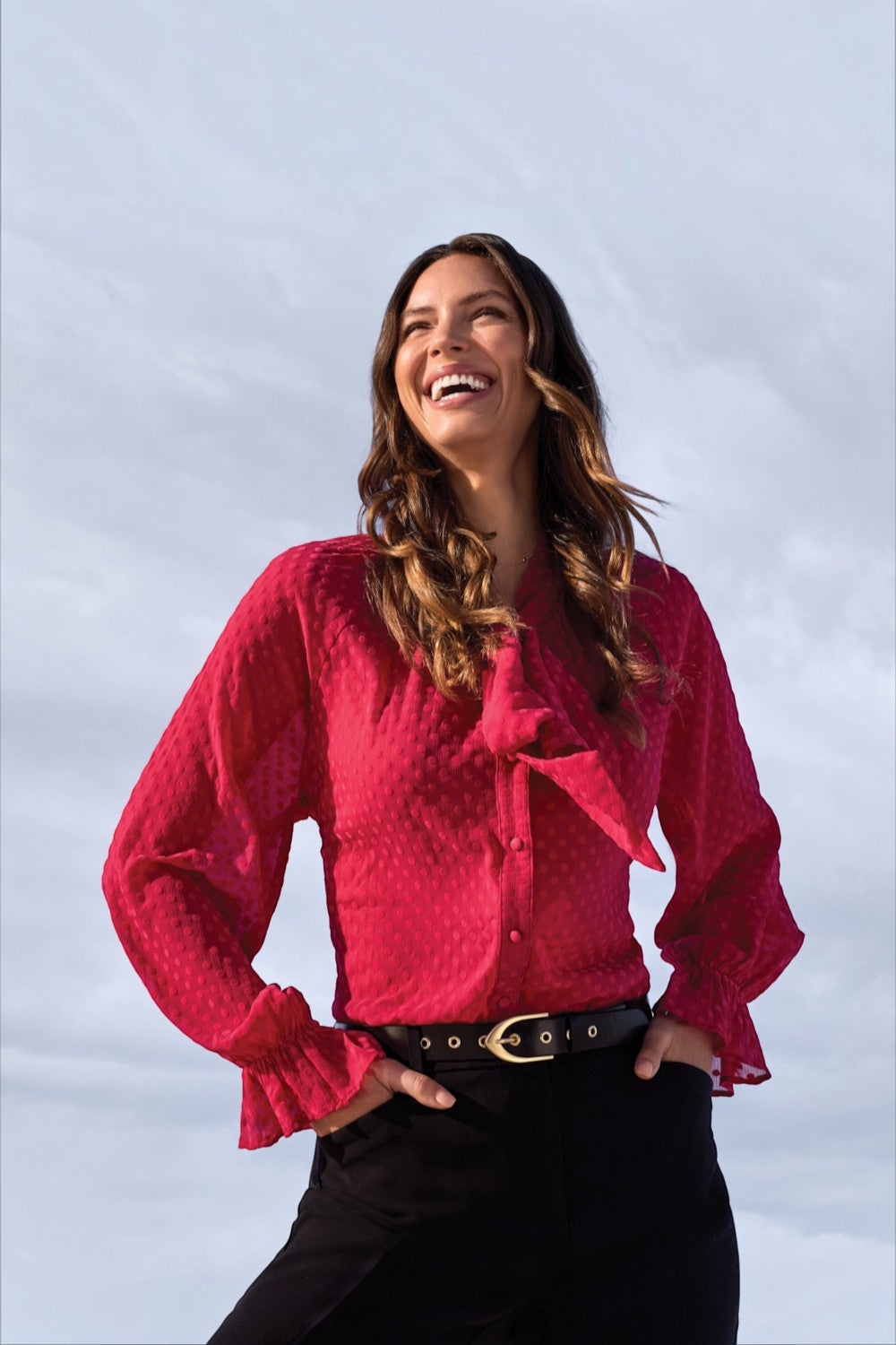 Broderick's Clothing Co. red sheer chiffon blouse with polka dot texture, bow-tie neck, and ruffled long sleeves.
