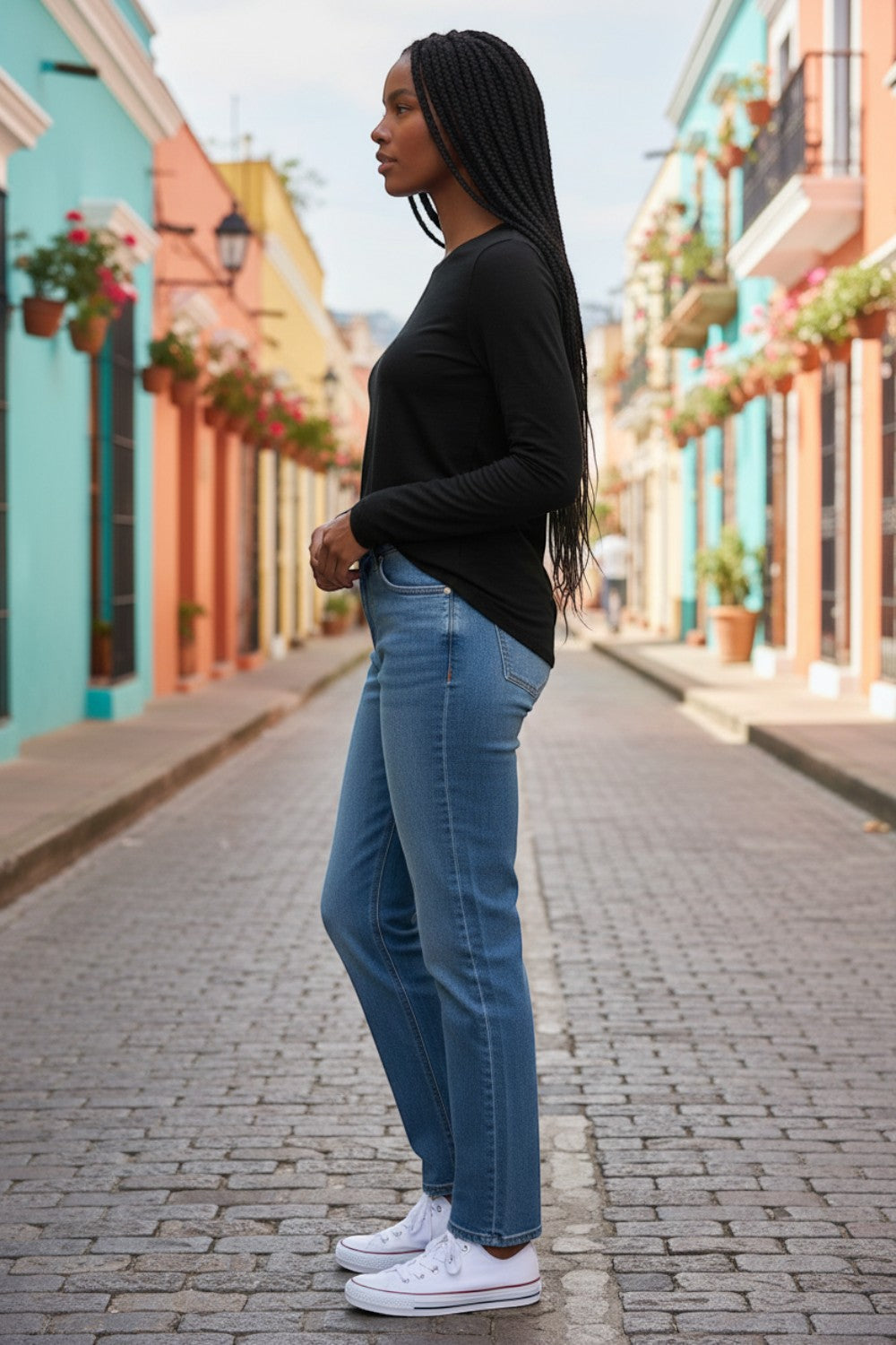 Broderick's Clothing Co. Shannon Passero Zoya black long-sleeve crew neck top worn with blue jeans on a city street.