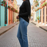 Broderick's Clothing Co. Shannon Passero Zoya black long-sleeve crew neck top worn with blue jeans on a city street.