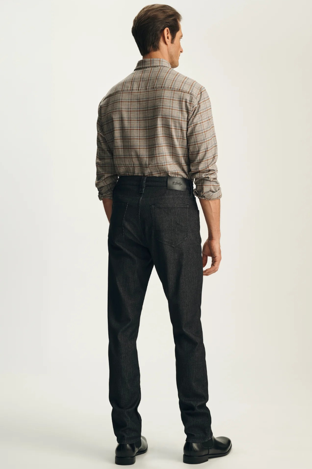 Broderick's Clothing Co. 34 Heritage Courage black straight leg jeans worn by a man in a plaid shirt, back view.
