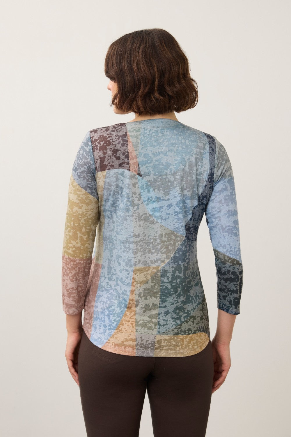 Back view of Broderick's Clothing Co. FDJ 3/4 sleeve notch neck top with a multi-colored abstract geometric pattern.