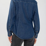 Back view of a woman wearing a Broderick's Clothing Co. medium-wash blue denim shirt with princess seams.
