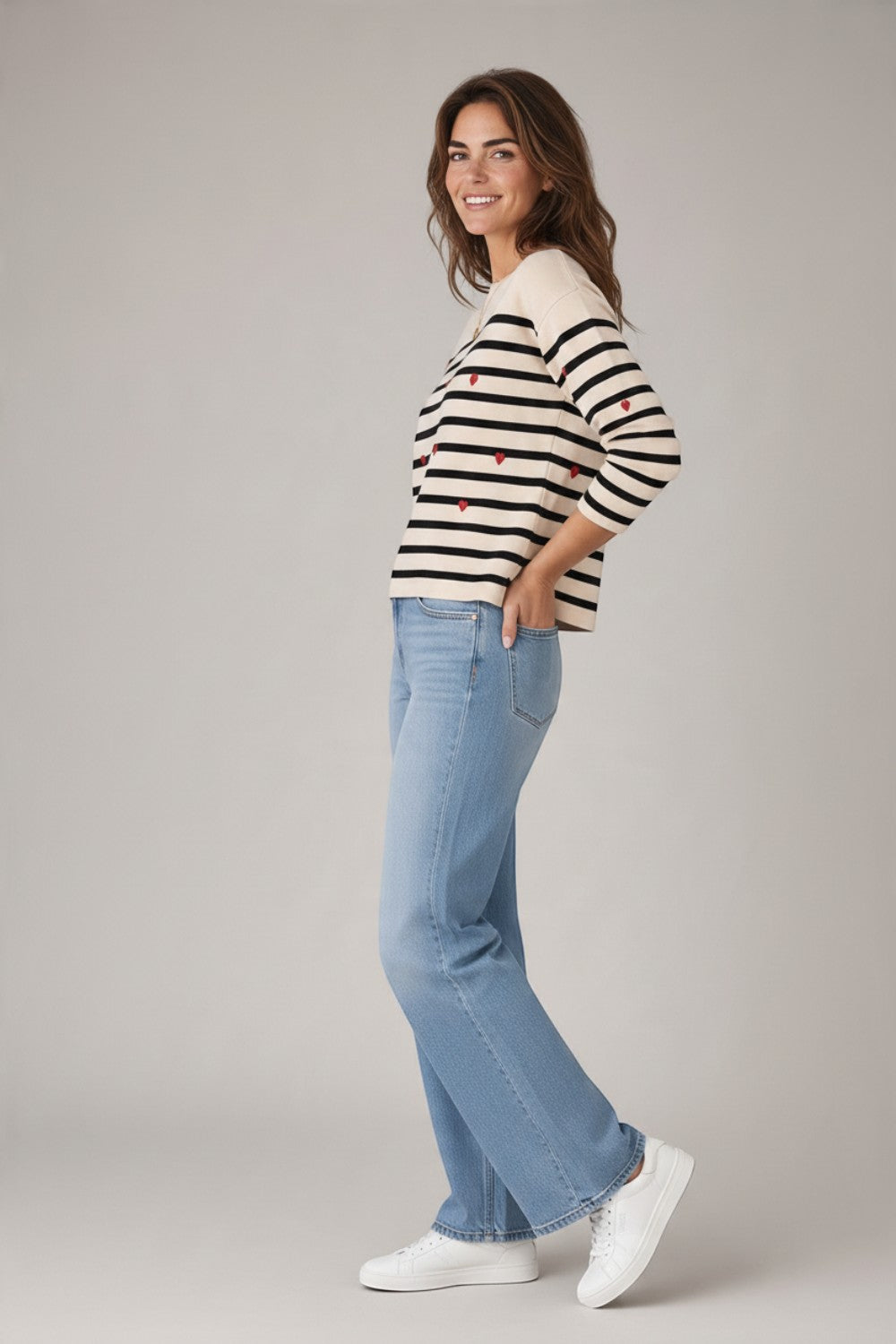 Broderick's Clothing Co. apricot striped sweater with red embroidered hearts, crew neck, and ribbed trim on a model.