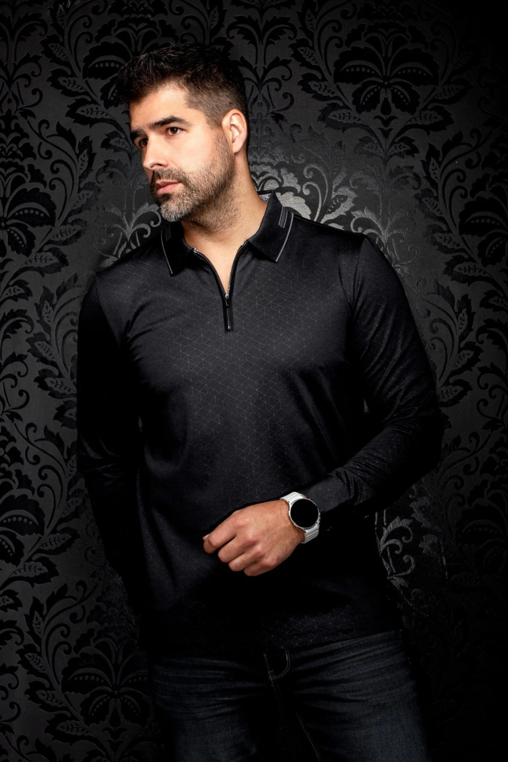 Man wearing a black Au Noir AVENOR long sleeve knit polo with a structured collar from Broderick's Clothing Co.