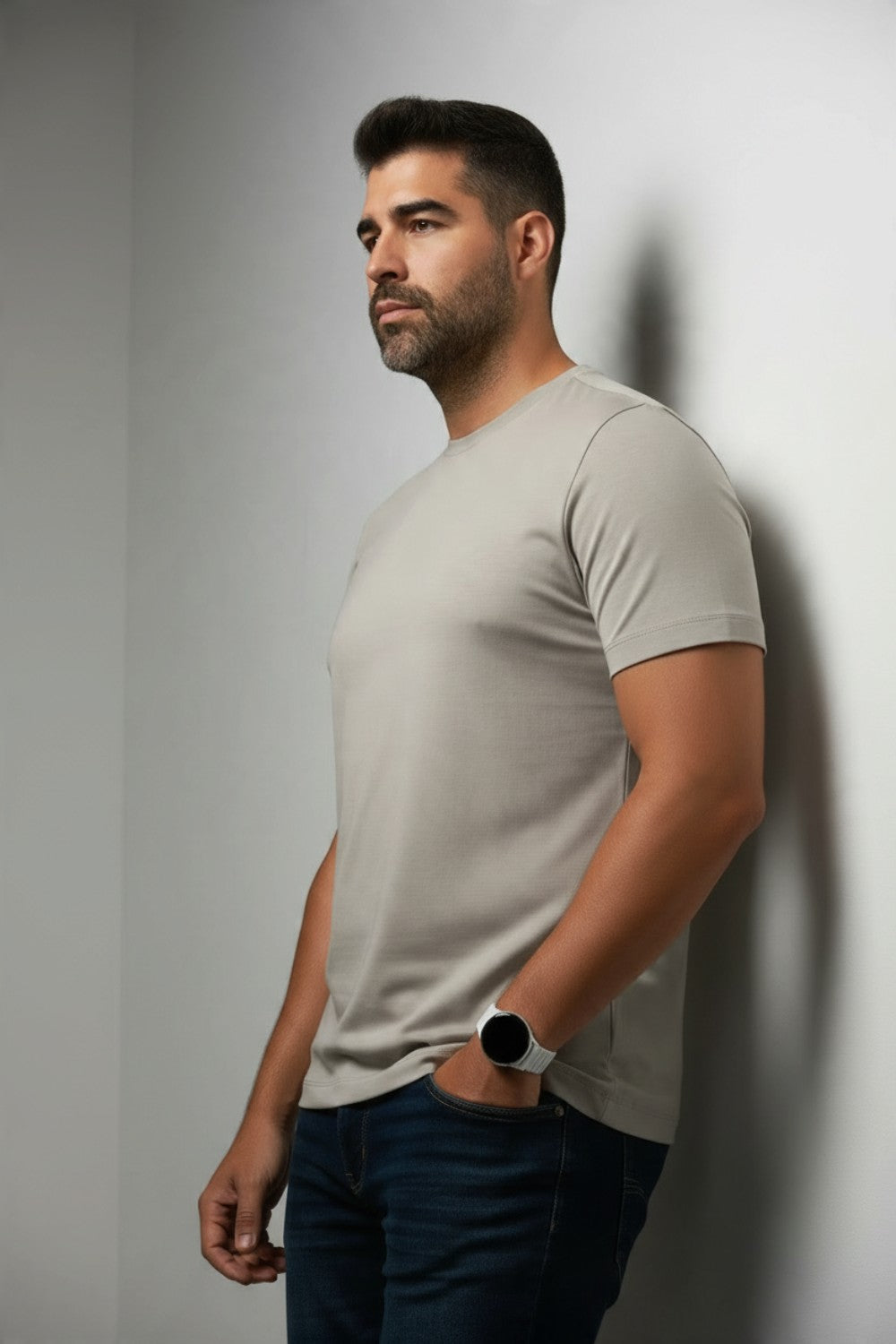 Broderick's Clothing Co. Au Noir C-MAVEN beige modal and mercerized cotton t-shirt worn by a man against a wall.